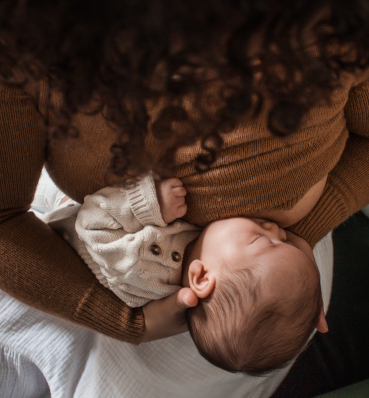 A tender moment between a mother and her child, as she lovingly nurses them.
